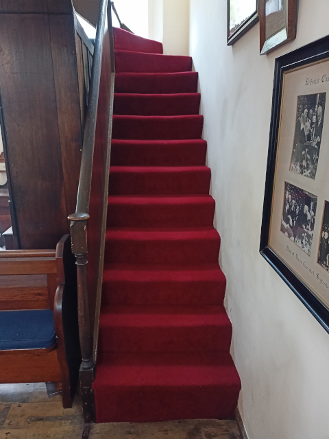 The lower steps to the gallery, carpetted.